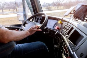 Commercial truck driver behind steering wheel on highway