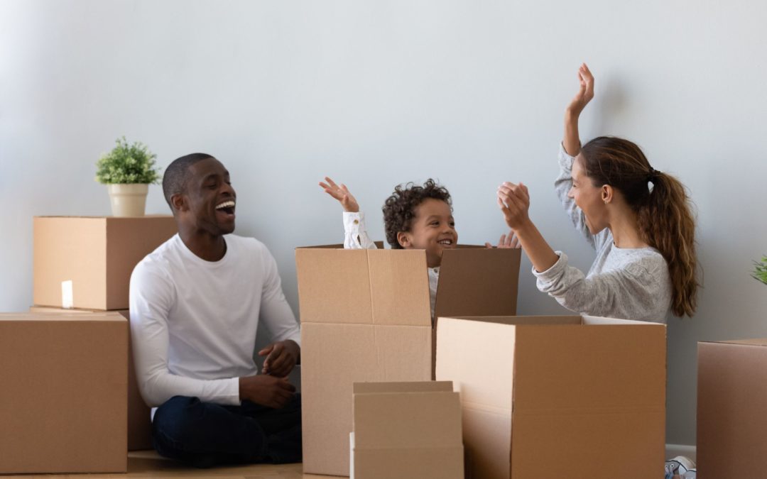 Mother & father playing with son in moving boxes