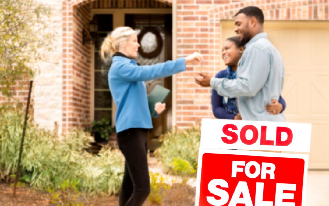 New homeowners getting house key from real estate agent