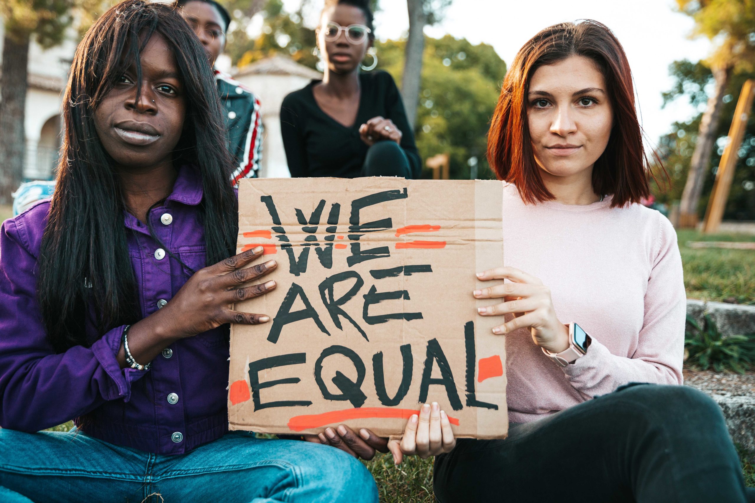 Una joven negra y una judía sostienen un cartel que dice Somos iguales