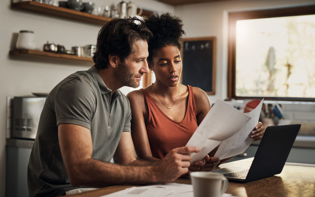 Young couple looking at a Living Will document in their kitchen