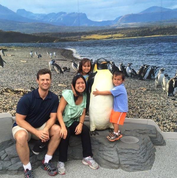 Family portrait at beach with penguins in background