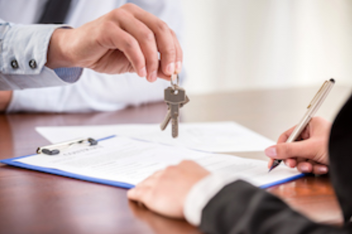 Commercial lease agent handing the keys to a business owner signing a building lease