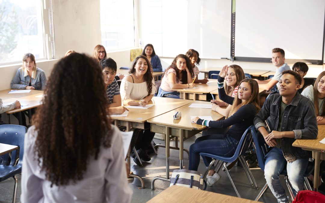 Highschool students listening to their teacher in a classroom