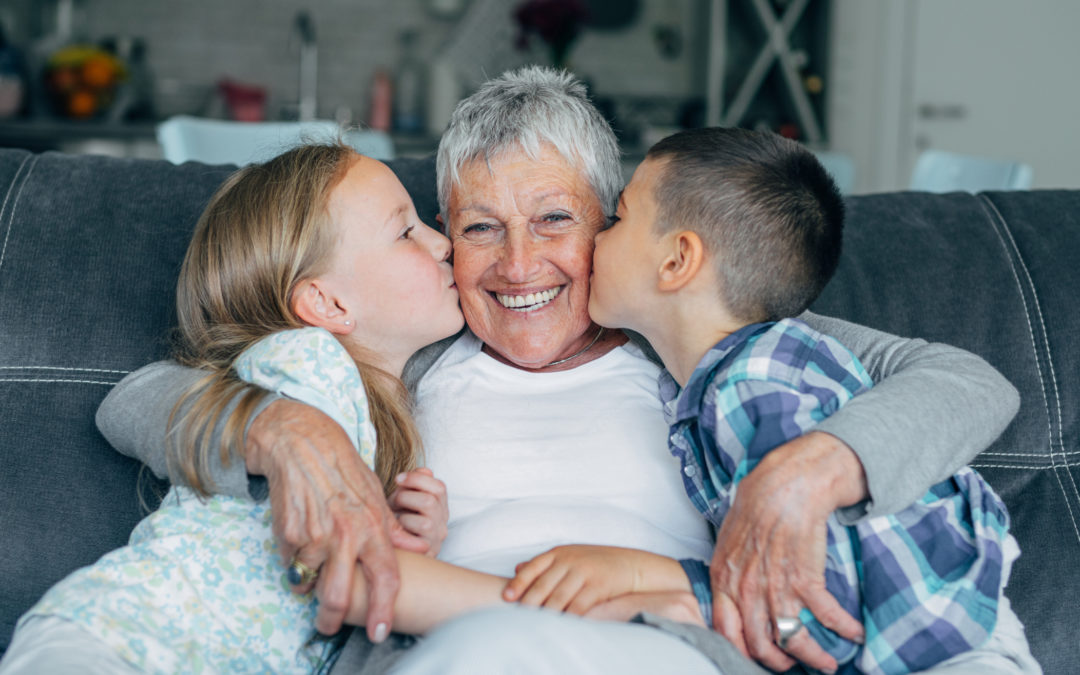 Abuela recibiendo besos de sus 2 nietos