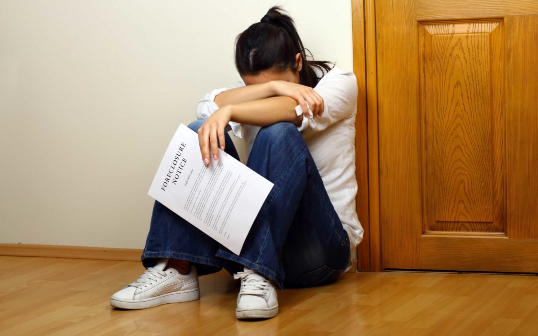 Distraught woman holding a Foreclosure Notice