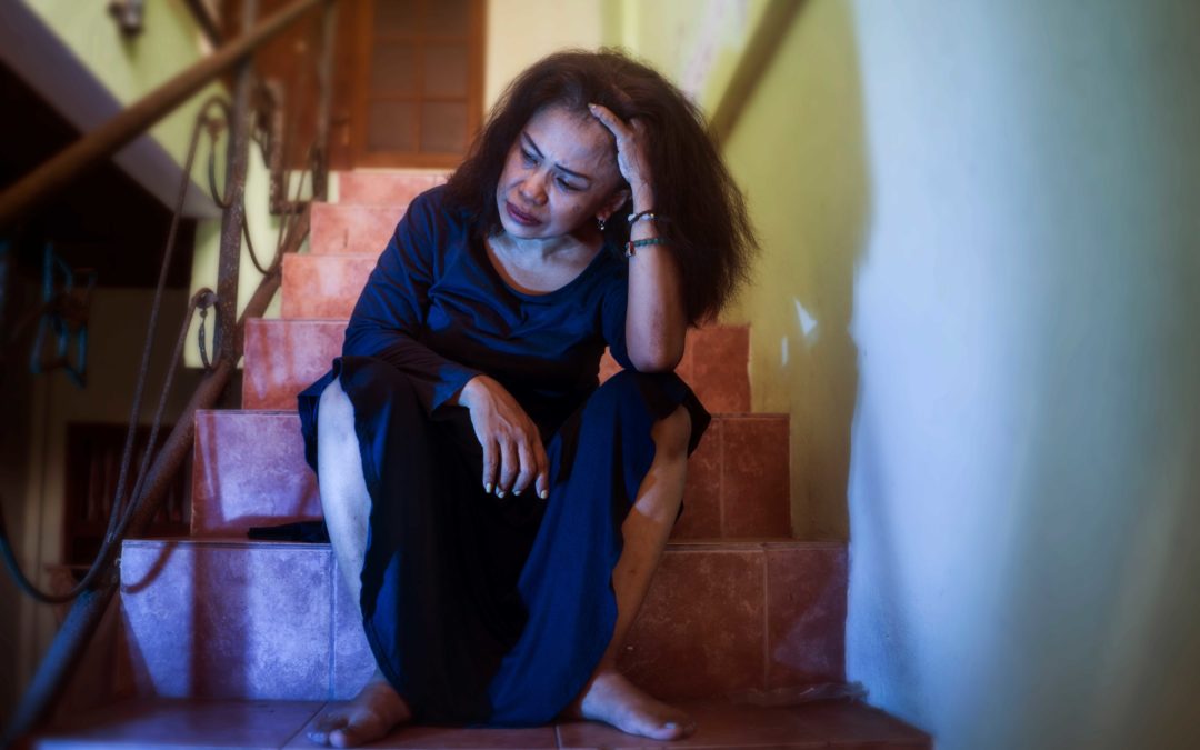 Mujer angustiada sentada en las escaleras de su apartamento