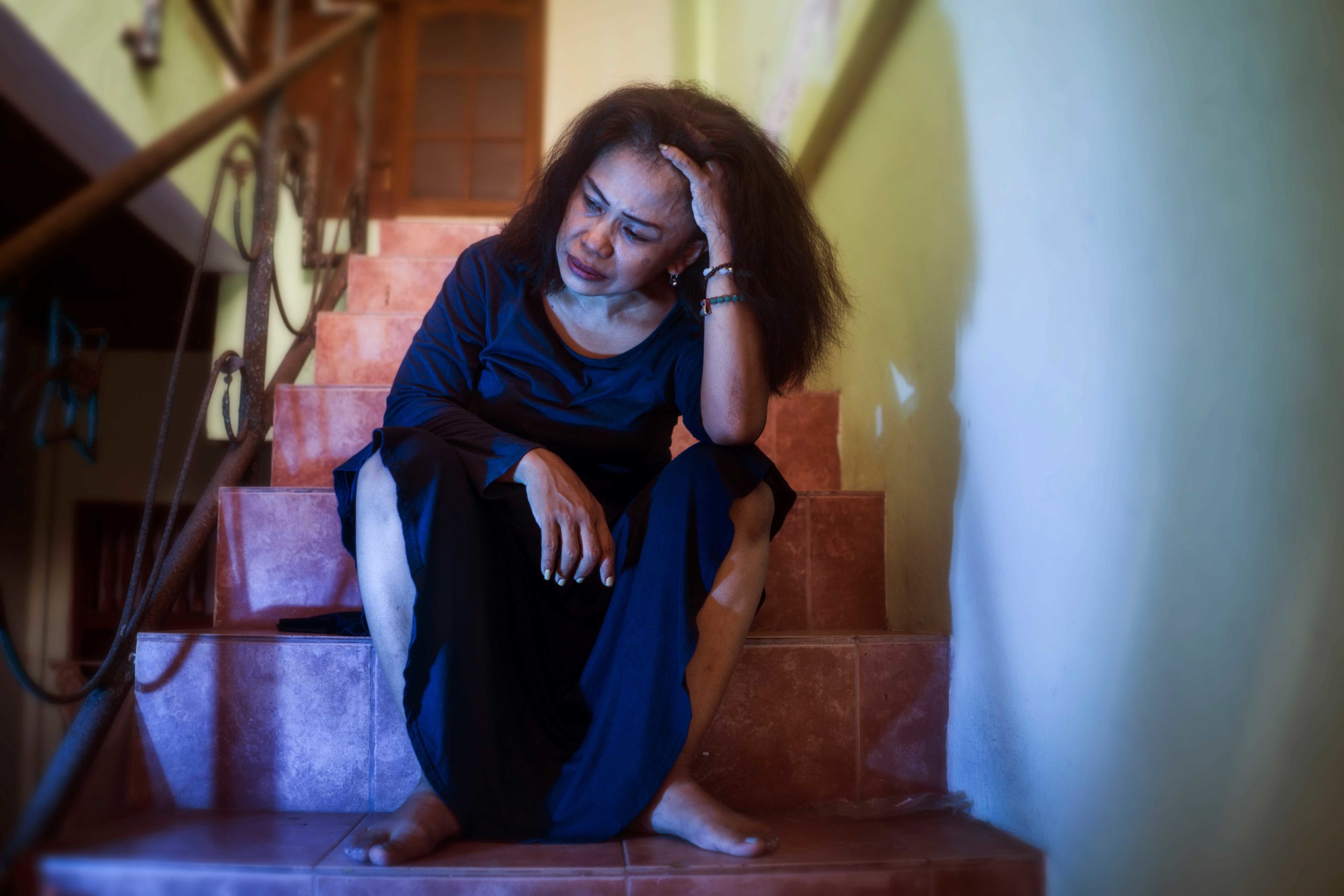 Mujer angustiada sentada en las escaleras de su apartamento