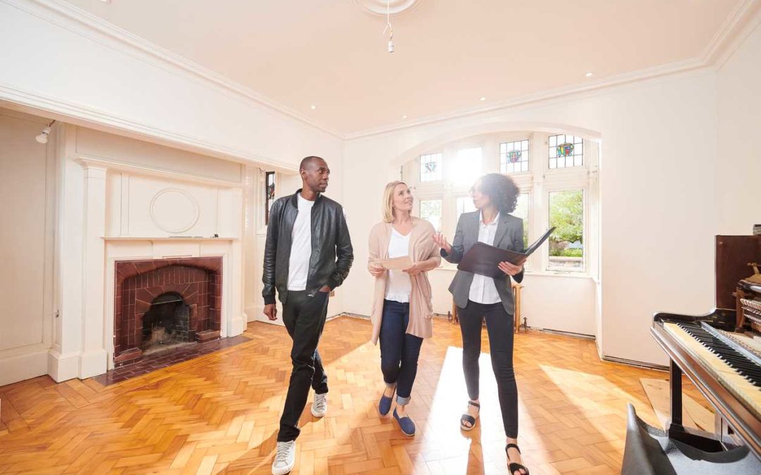 Agente inmobiliario que muestra una casa a compradores potenciales