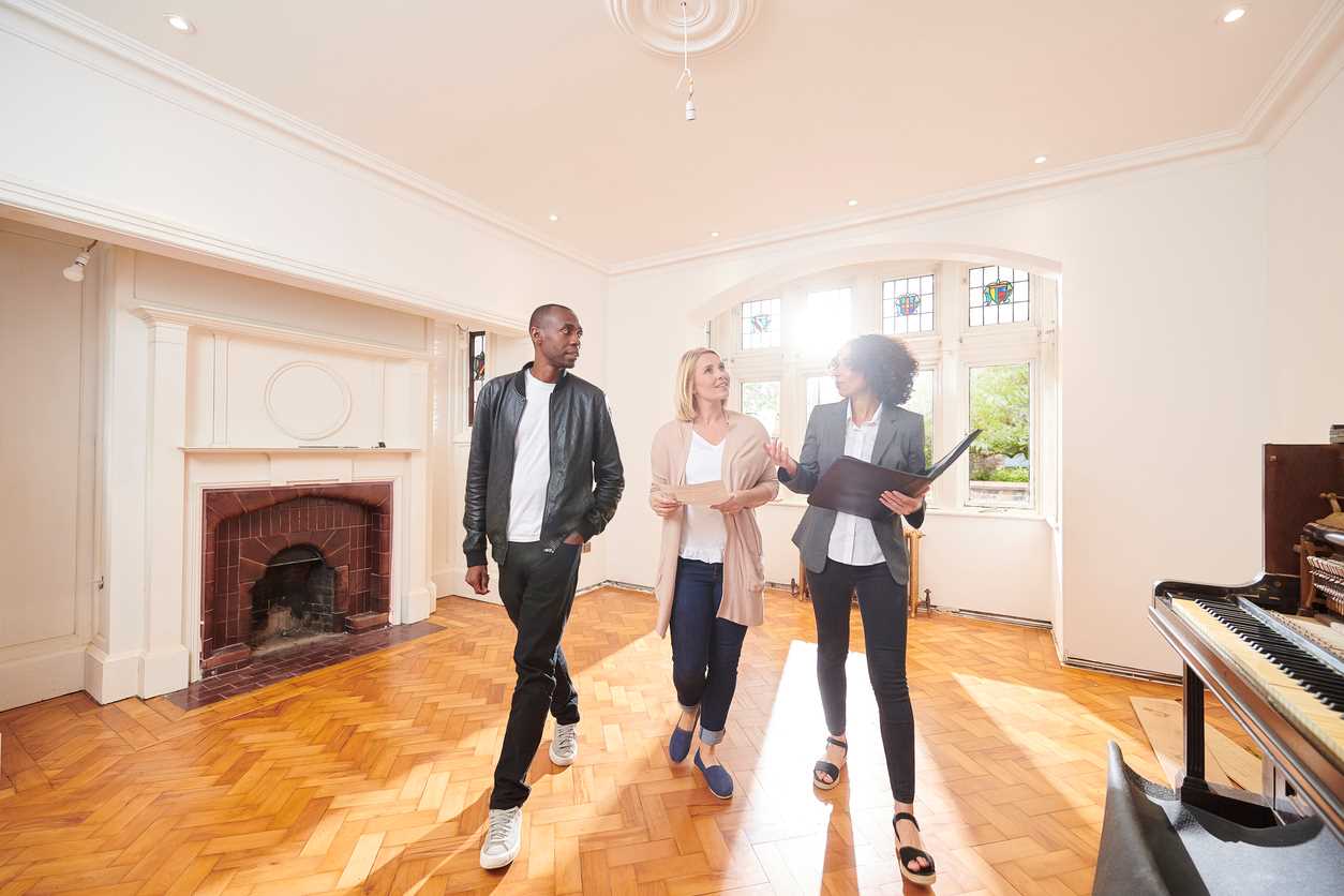 Un agente de bienes raíces que muestra una casa a compradores potenciales
