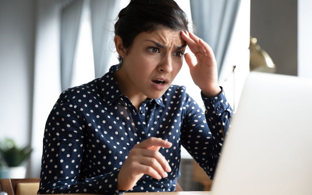 Mujer alarmada y preocupada mirando la pantalla de una computadora portátil