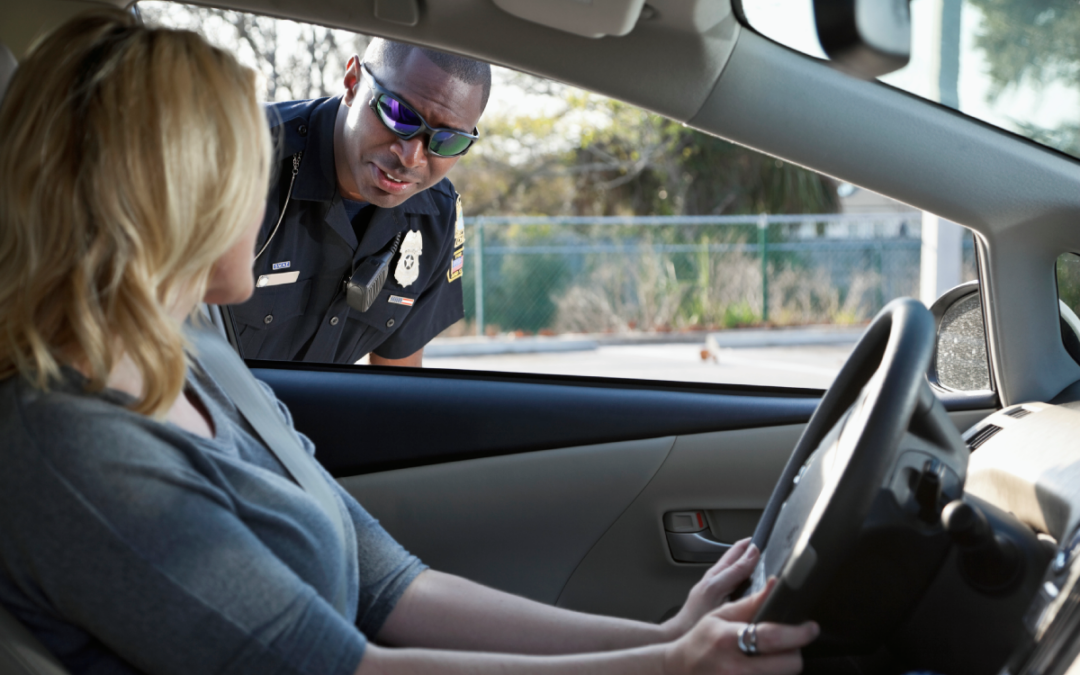 Mujer conduciendo recibiendo una multa de tráfico de un oficial de policía