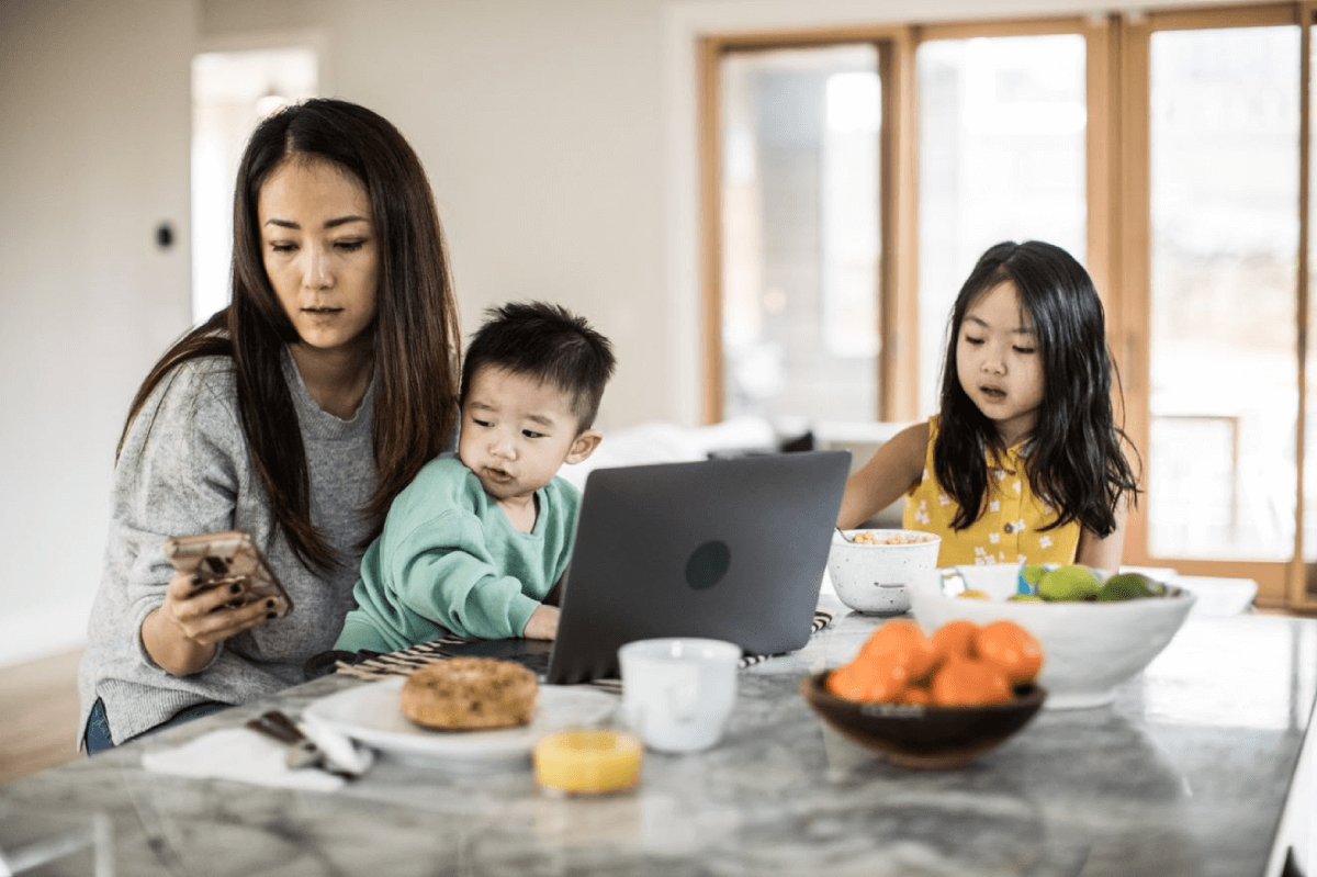 Asian mother and 2 children at home table