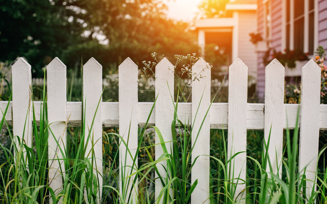 A white picket fence along a piece of real estate property.