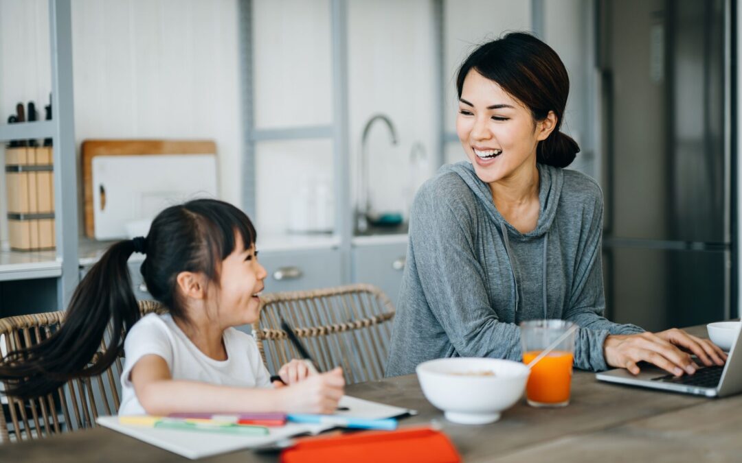 Mom working at breakfast table a young daughter colors
