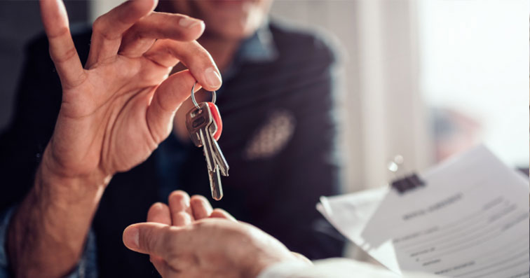 Agente inmobiliario entregando las llaves a un nuevo inquilino o propietario.