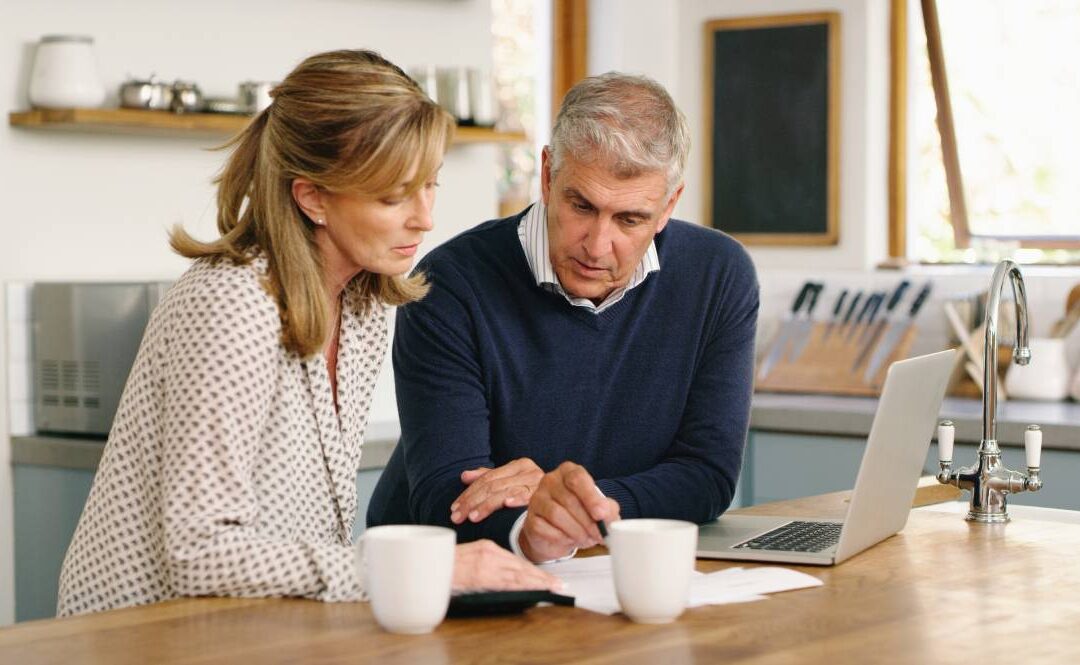 Man and woman looking at estate tax documents at a table in their home