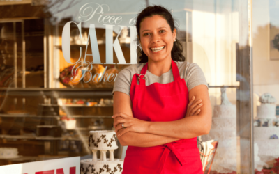 Smiling small business owner standing outside her Piece of Cake Bakery