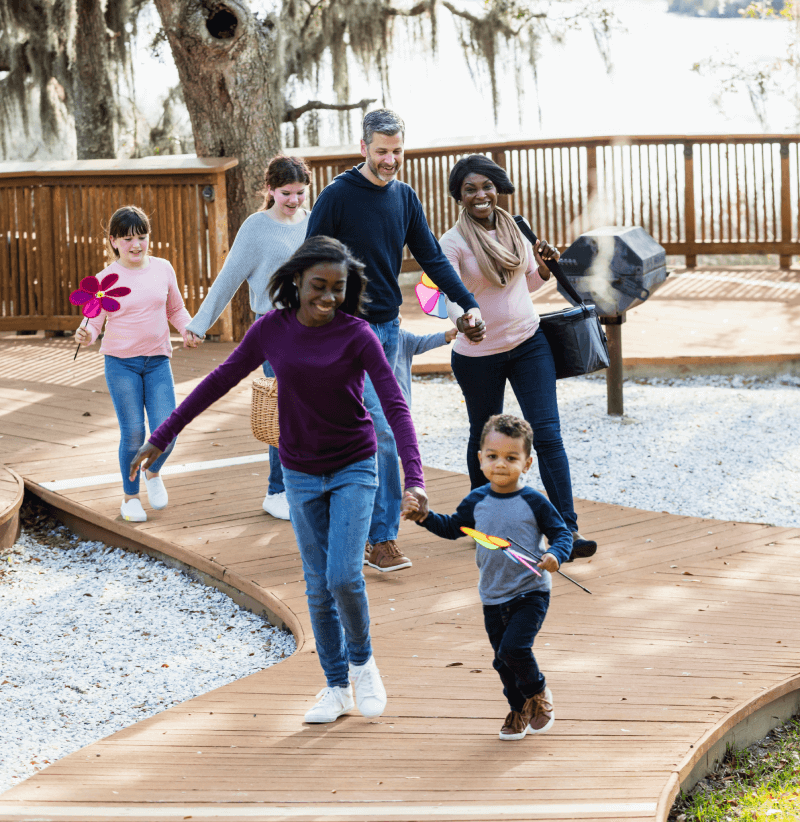 Una familia ensamblada en un parque paseando y corriendo juntos.
