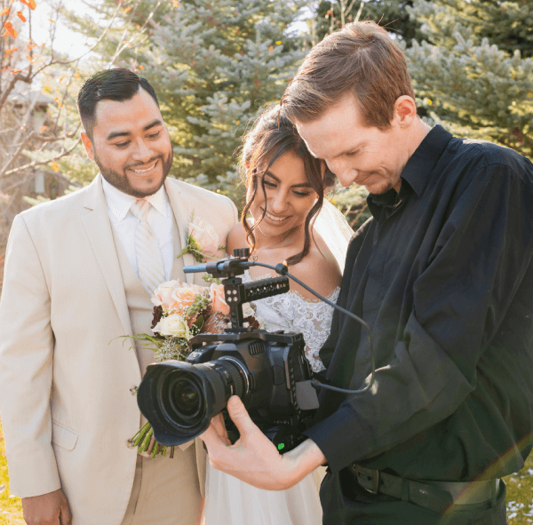 Pareja de recién casados mirando las fotos del evento con su fotógrafo