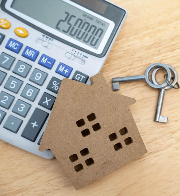 Calculator displaying 250000 laying next to a set of keys and a brown house cutout.