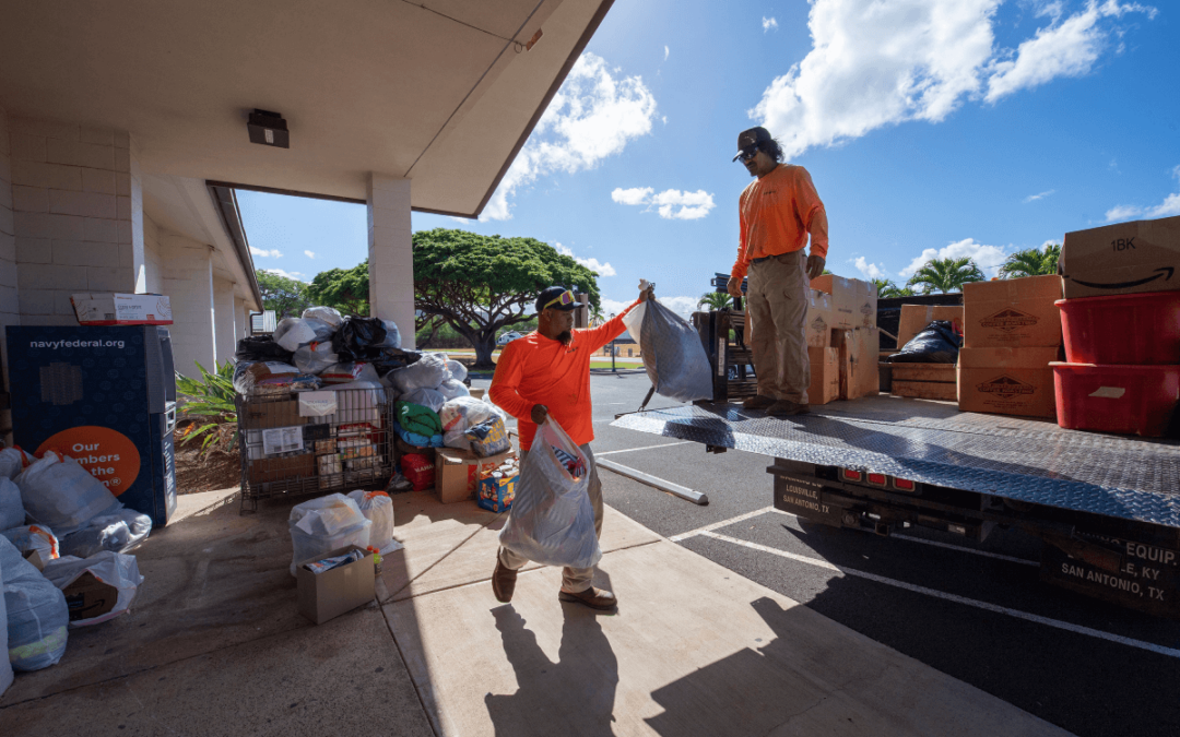 Los contratistas de Pacific Missile Range Facility, Albert Niau-Kanahele y David Planas, trasladan donaciones para que se envíen a Maui para ayudar a las víctimas de incendios forestales, en Pacific Missile Range Facility, Hawái, el 13 de agosto de 2023. PMRF, ubicada en la isla de Kauai, comenzó a recolectar donaciones tras los devastadores incendios forestales en Maui. (Foto de la Marina de los EE. UU. por Lisa Ferdinando)