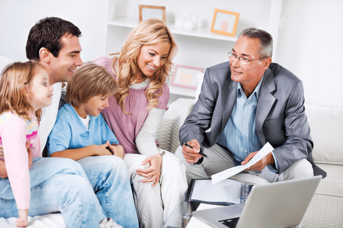 Un padre, una madre y dos hijos pequeños hablan con un abogado sobre la creación de un fideicomiso de planificación patrimonial.
