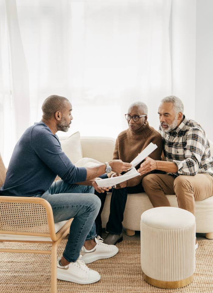 A lawyer explaining an legal elder law issue to an elderly couple in their living room.