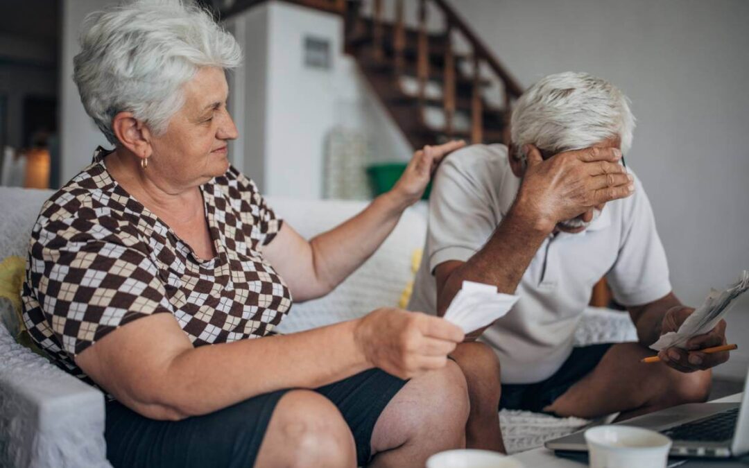 Elderly wife comforting husband after experiencing an elder financial exploitation event.