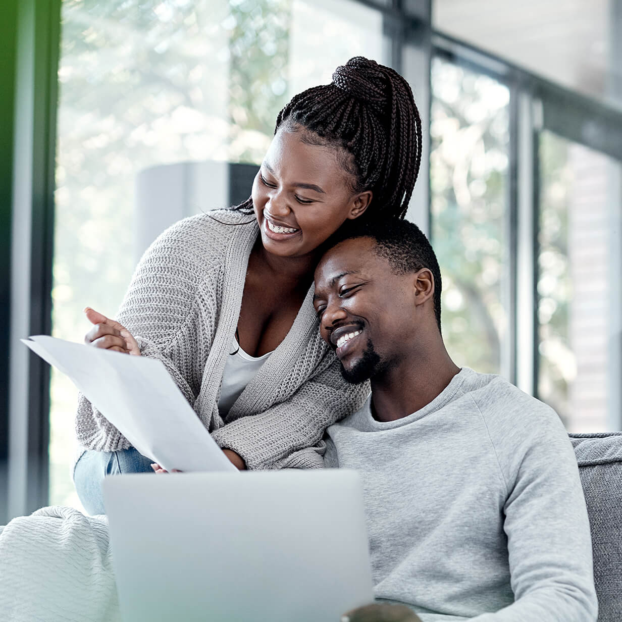 A couple is smiling while reviewing a real estate document