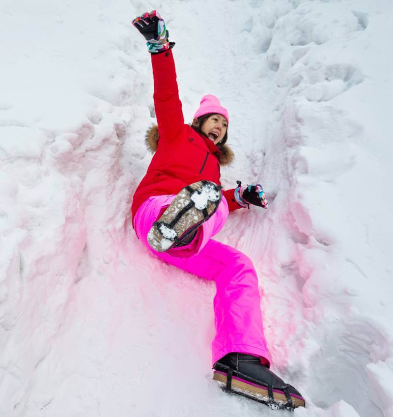 Woman falling on a snowy and icy sidewalk.