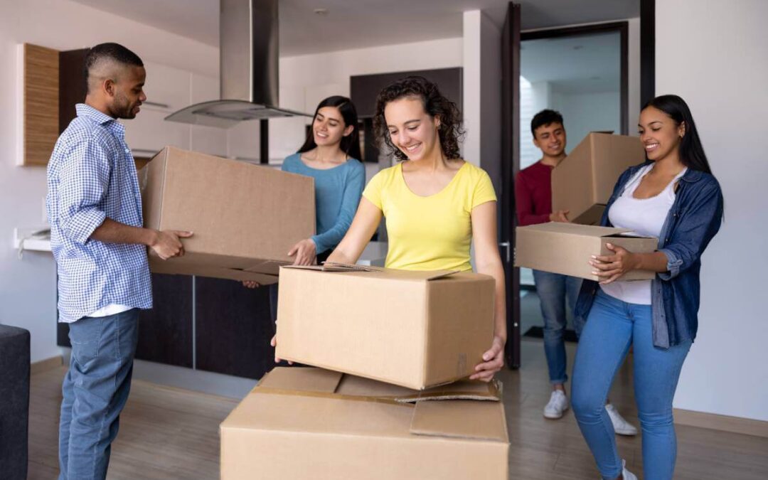 5 estudiantes universitarios trasladan cajas a su apartamento alquilado.