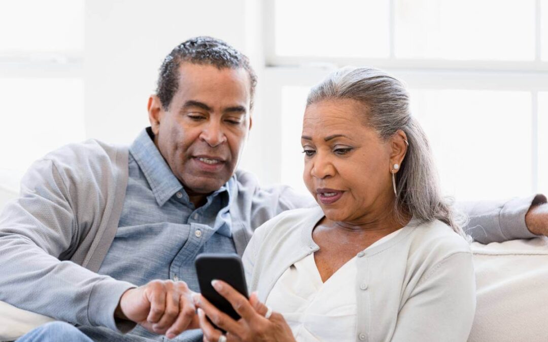 Couple looking at phone as they discuss retirement.