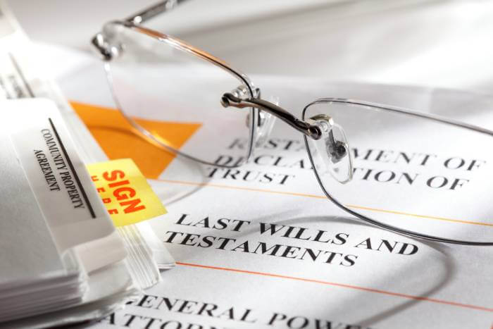 Estate planning documents with reading glasses laying on documents.