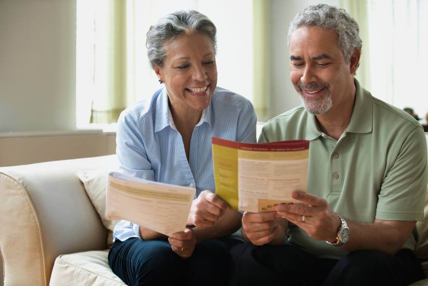 Smiling couple reviewing life insurance documents.