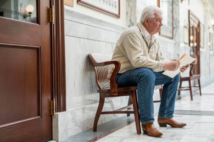 Man sitting outside a Small Claims courtroom waiting for his hearing.